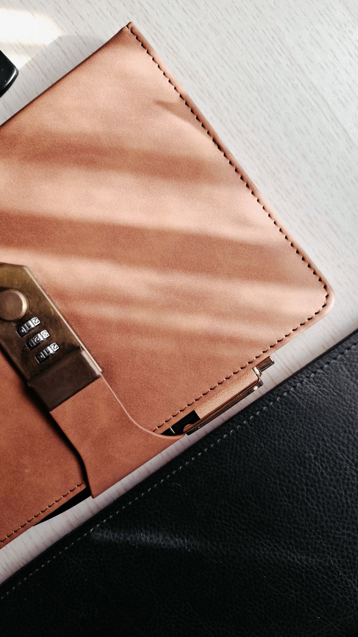 project-01-c Elegant leather portfolio with a security lock, casting soft shadows on a light surface.
